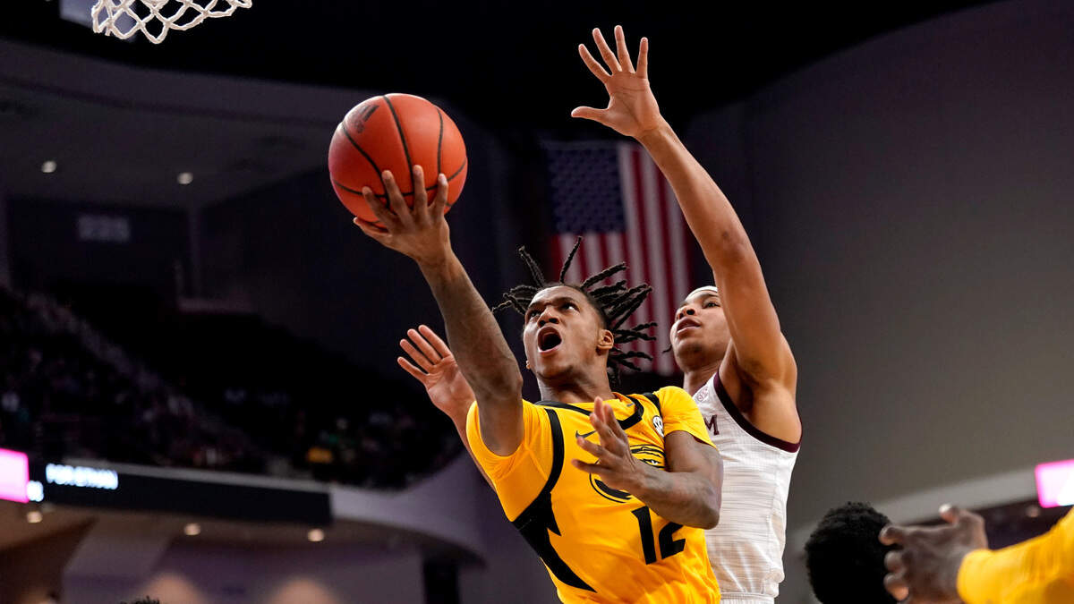 Missouri guard DaJuan Gordon (12) shoots over Texas A&M guards Wade Taylor IV (4) and Aaron Cash (0) during the first half of an NCAA college basketball game, Saturday, Feb. 5, 2022, in College Station, Texas. (AP Photo/Sam Craft)