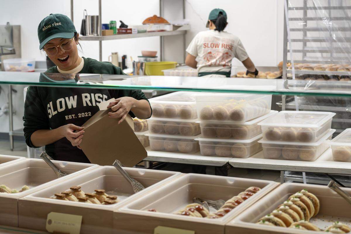 Doanh Ho laughs while packaging an order at Slow Rise on Friday, Jan. 23, 2026, in Overland Park.