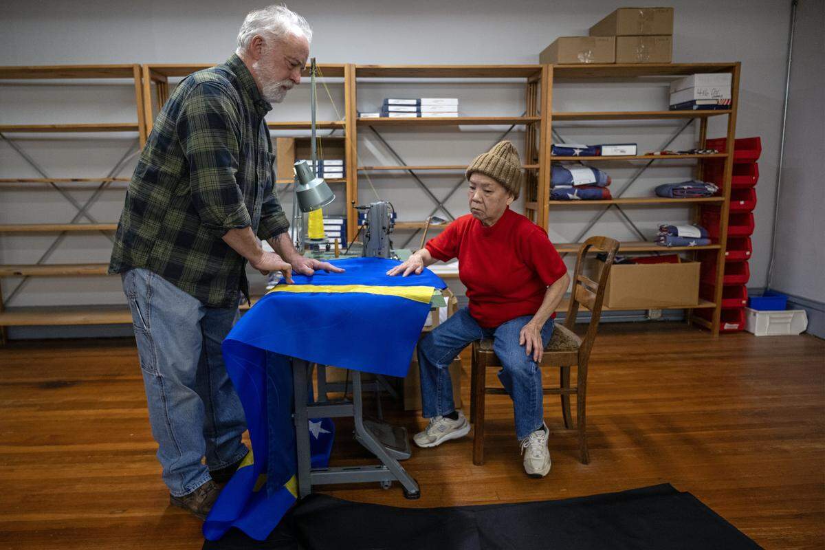 At All Nations Flag Co., custom order manager Randy Carney talks with seamstress Phuong-Thu Nguyen, 78, who was sewing the fabric together to make a flag from Curaçao on Thursday, Jan. 8, 2025 in Kansas City. Curacao is the smallest country participating in the FIFA World Cup matches in Kansas City this summer.