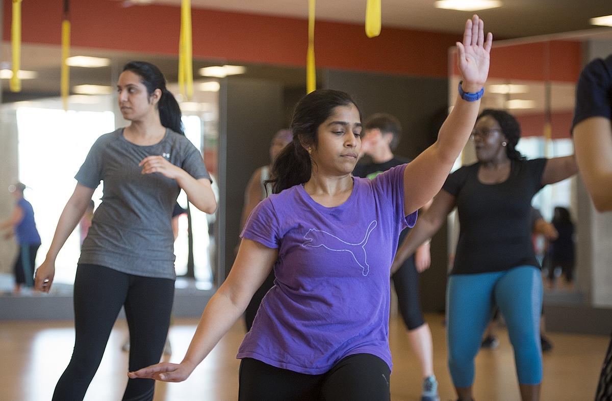 Pavani Gioranth, a software engineer at Cerner's Innovations Campus, takes a Zumba class alongside other employees over the lunch hour on Friday, April 27, in the Healthy Fitness center located on the campus. The fitness facility is free to employees and is often filled with 20- and 30-year-olds.