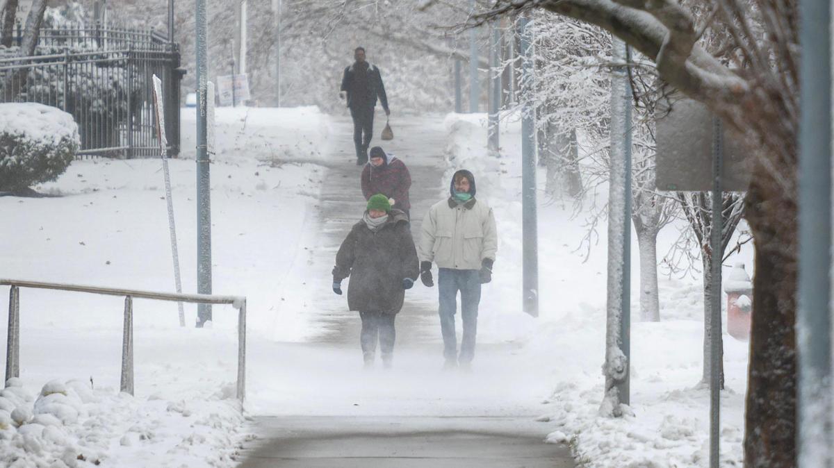 Heavy winds blow snow as pedestrians make their way down Armour Boulevard on Tuesday in Kansas City. Another winter storm with more snow is expected later this week.