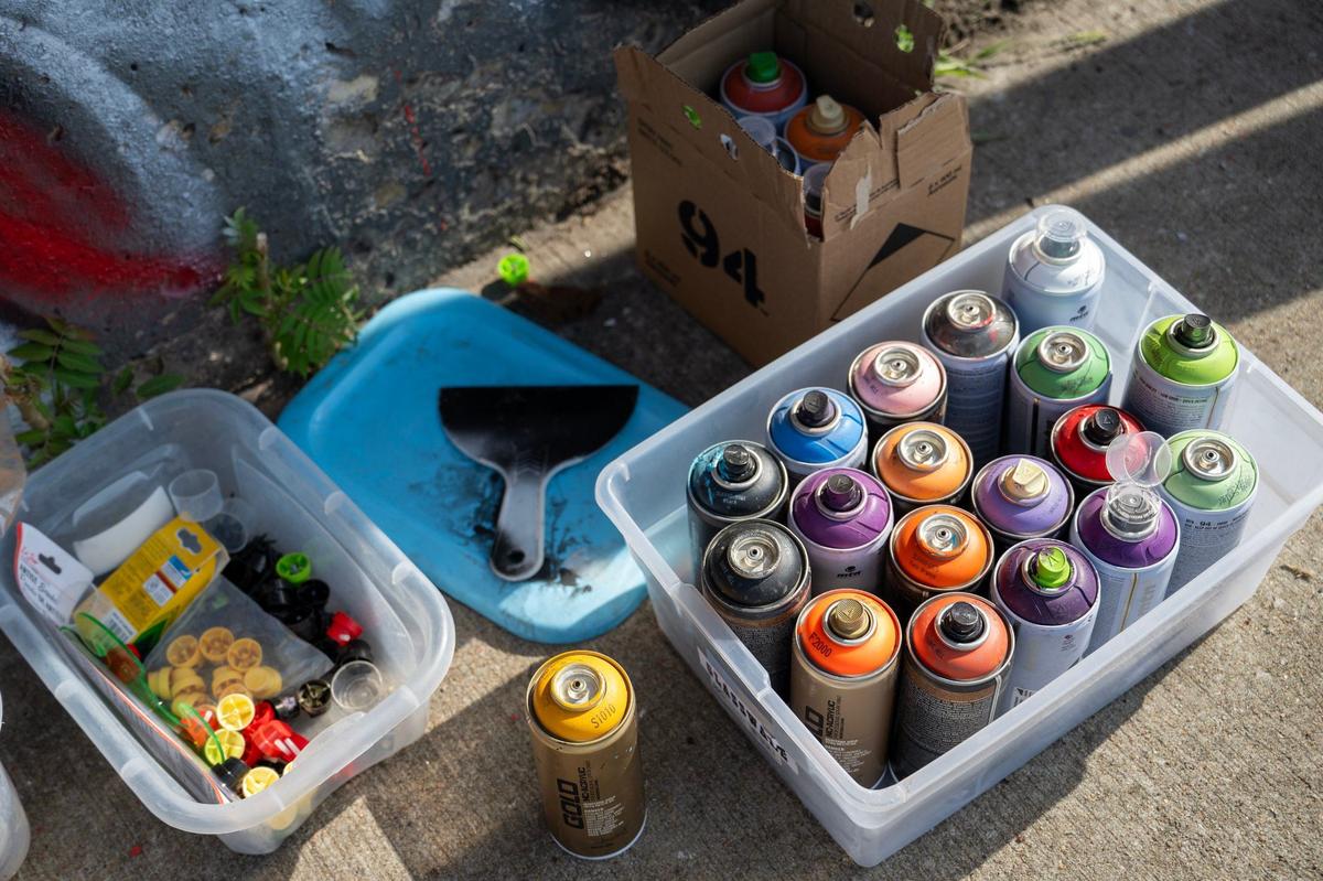 Artist Mike Elder uses aerosol cans of paints to create his mural on the Independence Avenue truck-eating bridge.