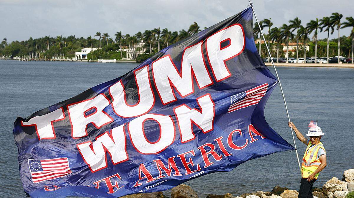 UN PARTIIDARIO del presidente electo, Donald Trump, iza una bandera en Palm Beach, Florida, el 6 de noviembre de 2024, tras su victoria en las elecciones presidenciales. (Foto de Kyodo News/Sipa USA) Open in Google Translate
