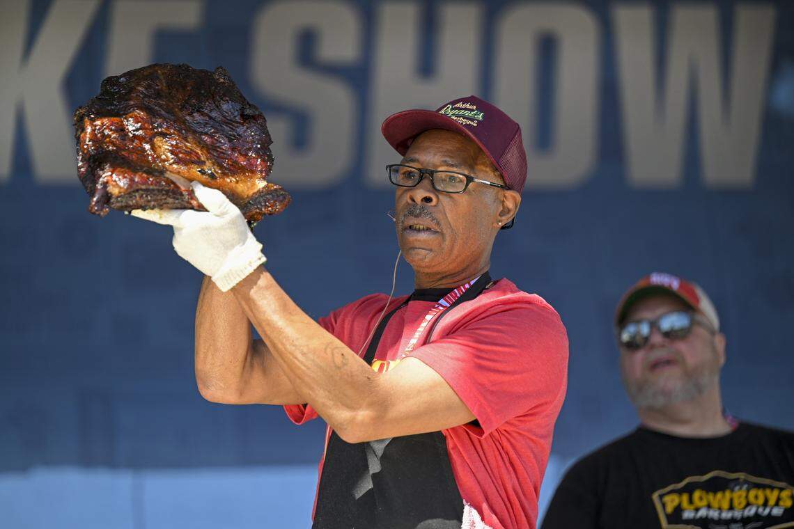 Pit master Wayne Garrett of Arthur Bryant’s Barbeque, pulled a brisket from the smoker, as Todd Johns, owner of Plowboys Barbeque, looked at the KC Smoke Show at the NFL Draft on Saturday, April 29, 2023, in Kansas City.