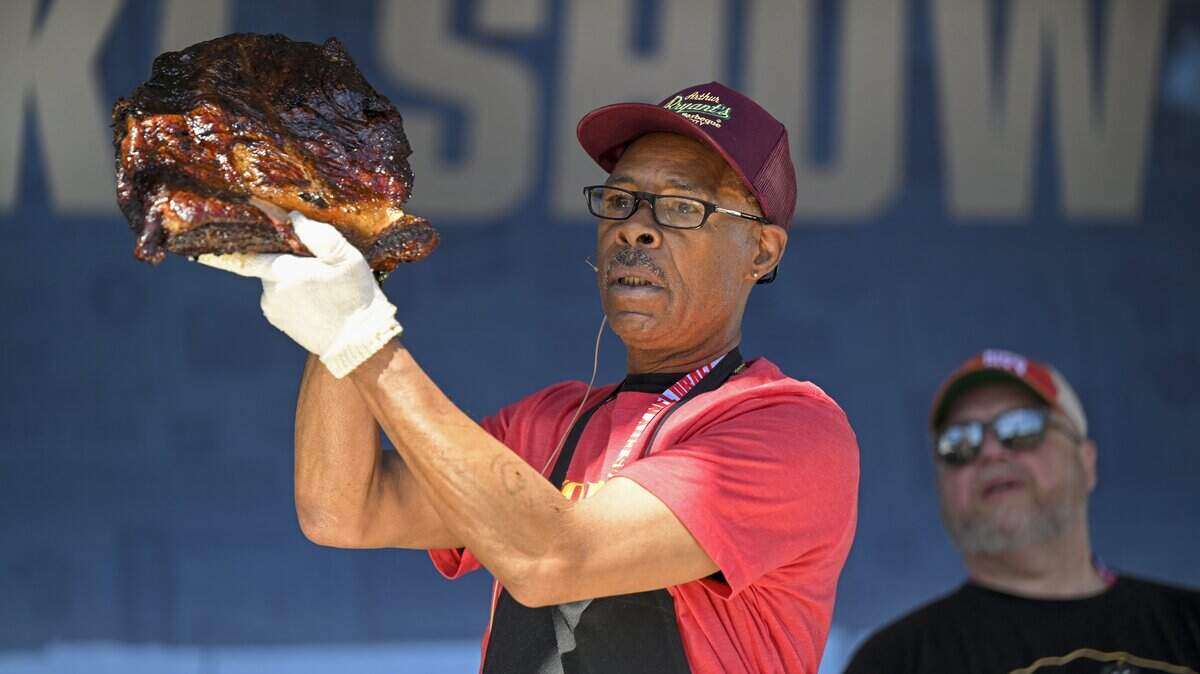 Pit master Wayne Garrett of Arthur Bryant’s Barbeque, pulled a brisket from the smoker, as Todd Johns, owner of Plowboys Barbeque, looked at the KC Smoke Show at the NFL Draft on Saturday, April 29, 2023, in Kansas City.