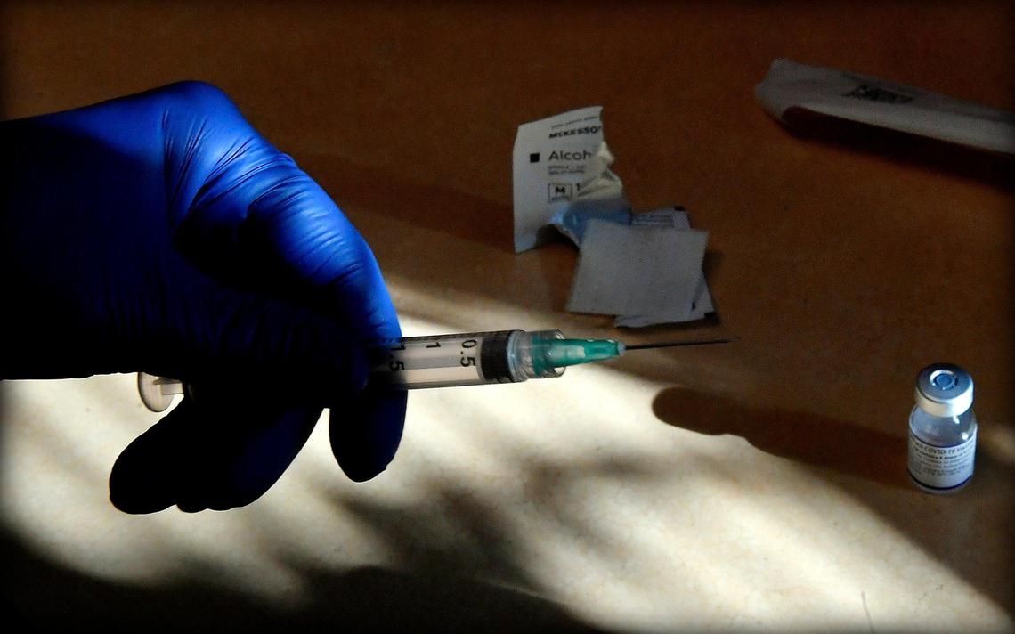Breana Slusser, a medical assistant at Family Health Care KC, prepares a COVID-19 vaccination booster shot Tuesday afternoon at the clinic in Kansas City, Kansas.