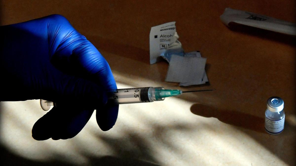 Breana Slusser, a medical assistant at Family Health Care KC, prepares a COVID-19 vaccination booster shot Tuesday afternoon at the clinic in Kansas City, Kansas.