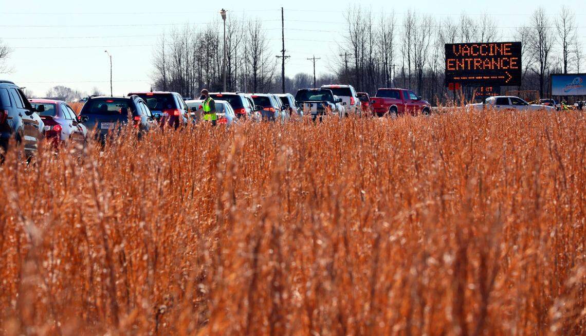 In this Jan. 22, 2021, file photo, vehicles snake through a line beside a farm field in Poplar Bluff, Mo., for the state’s first mass COVID-19 vaccination event.