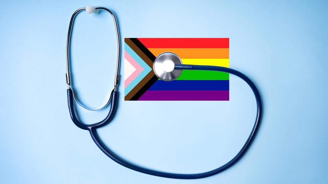 Inclusive pride flag and stethoscope on blue background. Equipment for Medical, Health care and patient, Failure and Diseases concept. lgbt lgbtq gay lesbian transgender bisexual healthcare trans