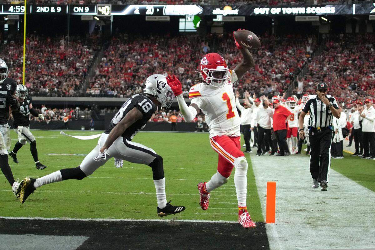 Kansas City Chiefs wide receiver Xavier Worthy (1) scores on a 9-yard touchdown reception against Las Vegas Raiders cornerback Jack Jones (18) in the second half at Allegiant Stadium.