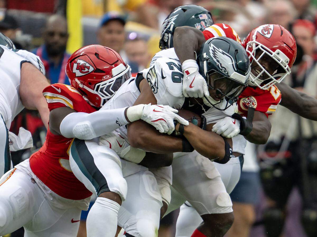 Kansas City Chiefs defensive end Charles Omenihu (90) and safety Chamarri Conner (27) stop Philadelphia Eagles running back Saquon Barkley (26) in the second half at GEHA Field at Arrowhead Stadium on Sunday, Sept. 14, 2025, in Kansas City.