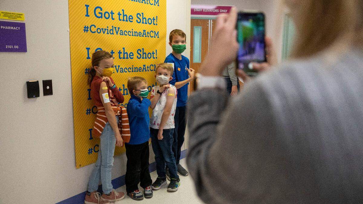 Sarah Edwards takes a photo of her children after they recently received their first COVID-19 vaccine at Children’s Mercy Hospital-Kansas in Overland Park, Kansas.