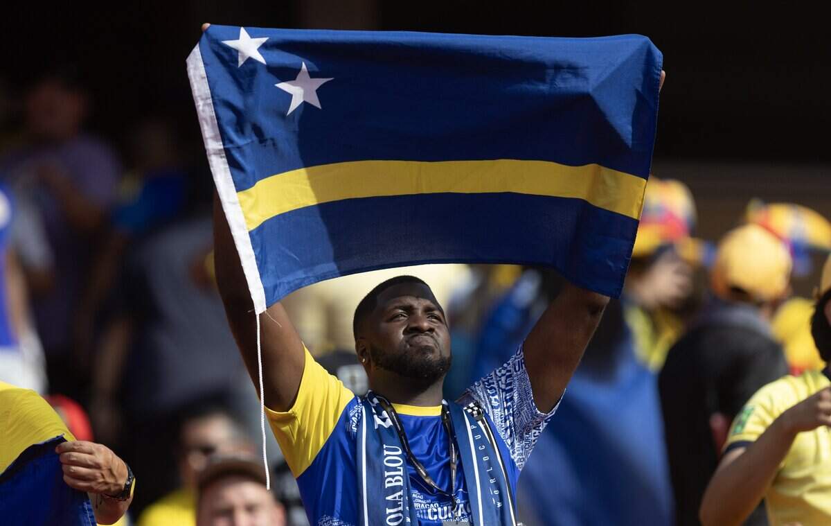A Curaçao fan holds up his country's flag before a FIFA World Cup group-stage soccer match against Ecuador at Kansas City (Arrowhead) Stadium in Kansas City on Saturday, June 20, 2026.