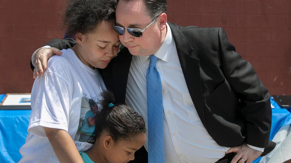 Doug Langner, executive director of Hope Faith shelter, hugged Kira Washington and Kemya Washington, 6, during a memorial for Marcia Boring, 52, and Eugene Shaw, 50, who were found dead May 6. Both were clients of the shelter. Kansas City police are investigating it as a double homicide.
