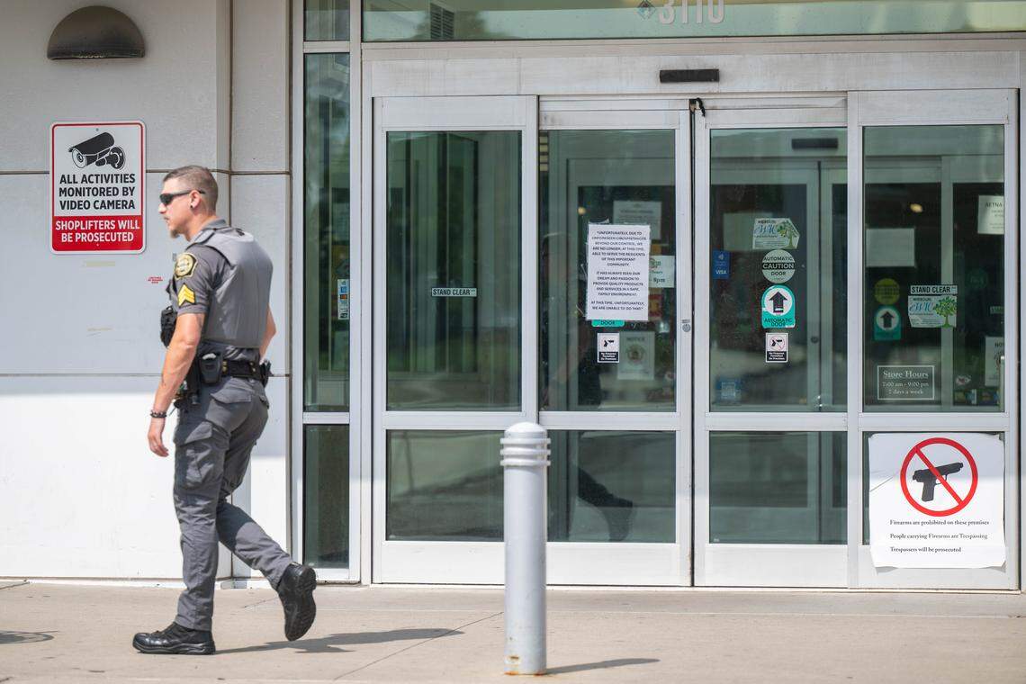 A security guard walks past Sun Fresh Linwood with a sign on the door announcing to customers that it would not reopen, on Wednesday, Aug. 13, 2025, in Kansas City. The troubled grocery store closed the previous day.