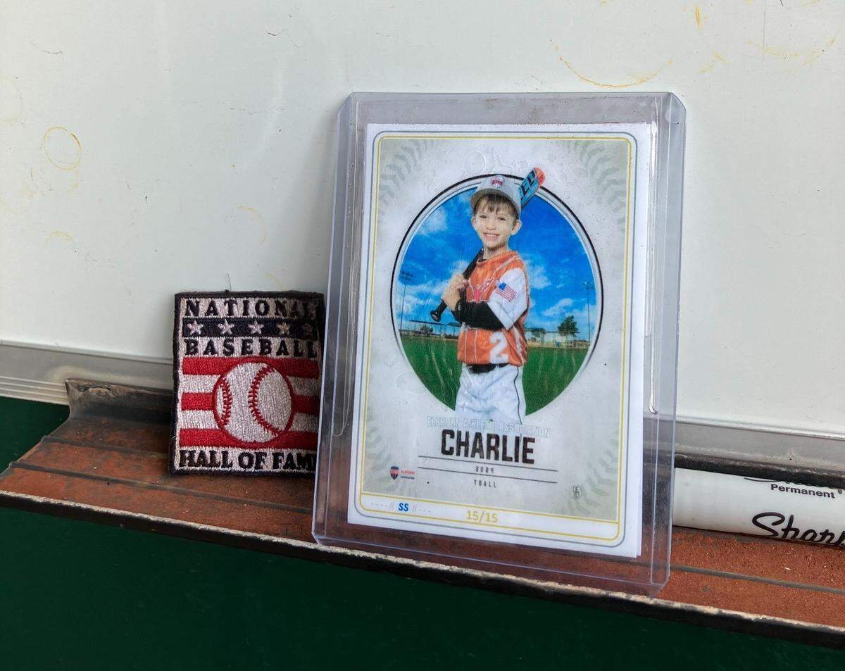 The baseball card of a 4-year-old named Charlie sits inside the Royals dugout.