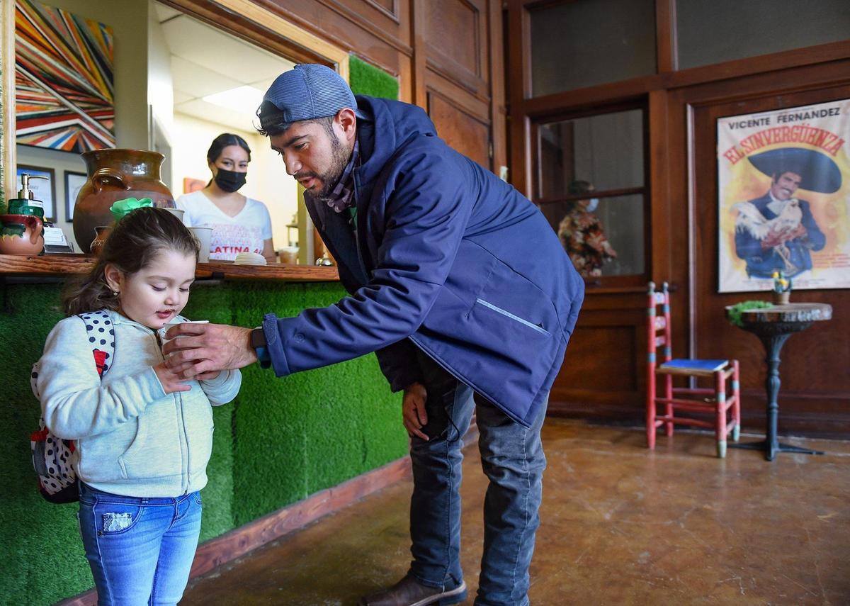 As owner Lesley Reyes looks on, Miguel Sierra of Lee’s Summit helps his daughter, Kimberly, 3, with an Abuelita Lupe, a Mexican hot chocolate. Sierra drove there to try the coffee native to his homeland. “It reminds me of home,” he said.