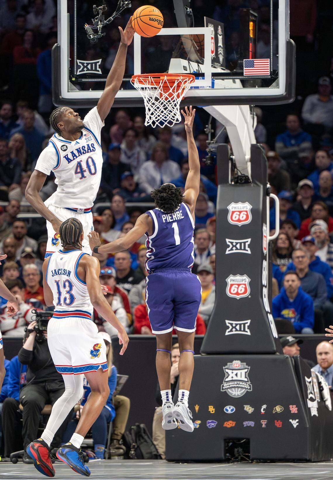 Kansas Jayhawks forward Flory Bidunga (40) blocks a layup by Texas Christian University Horned Frogs guard Jayden Pierre (1) during the second half of a Big 12 Men's Basketball Tournament game at T-Mobile Center on Thursday, March 12, 2026, in Kansas City.