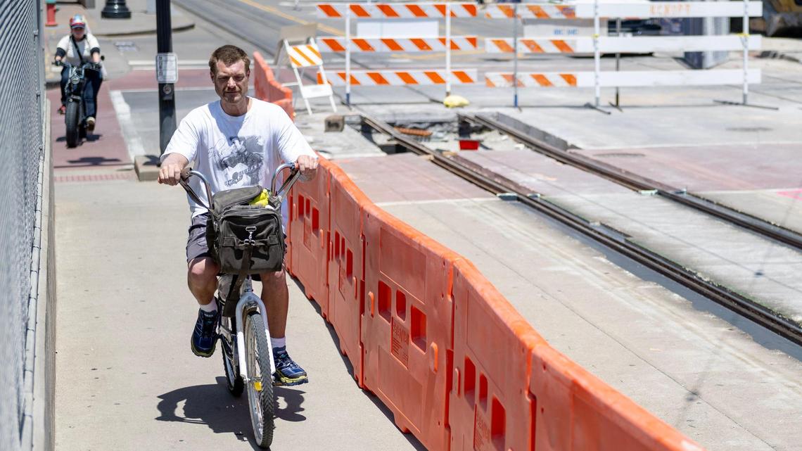 Bicyclists ride on the sidewalk on Main Street bridge Friday over Interstate 670 as it remains closed due to damaged KC Streetcar track.