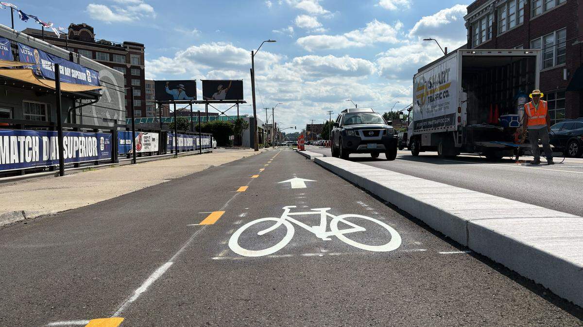 Workers add turn arrows at Baltimore Avenue as part of the Southwest Boulevard road diet project in Kansas City’s Crossroads district.