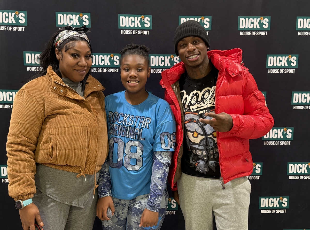 Chiefs wide receiver poses with a family that received the shopping spree and holiday experience with his Worthy 1’s foundation.