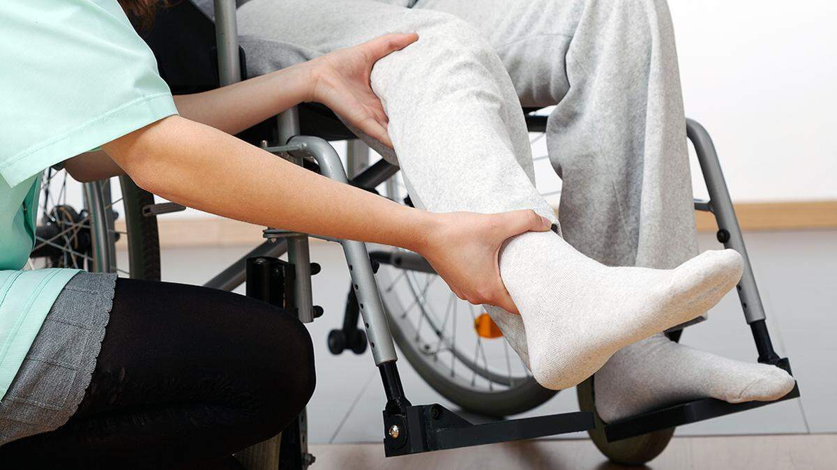 Young physiotherapist exercising with elder disabled person health care healthcare senior citizen physical therapy