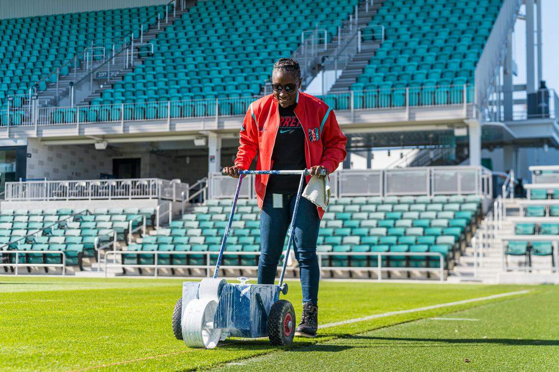 KC Current president Raven Jemison paints the lines at CPKC Stadium ahead of the 2025 NWSL season.