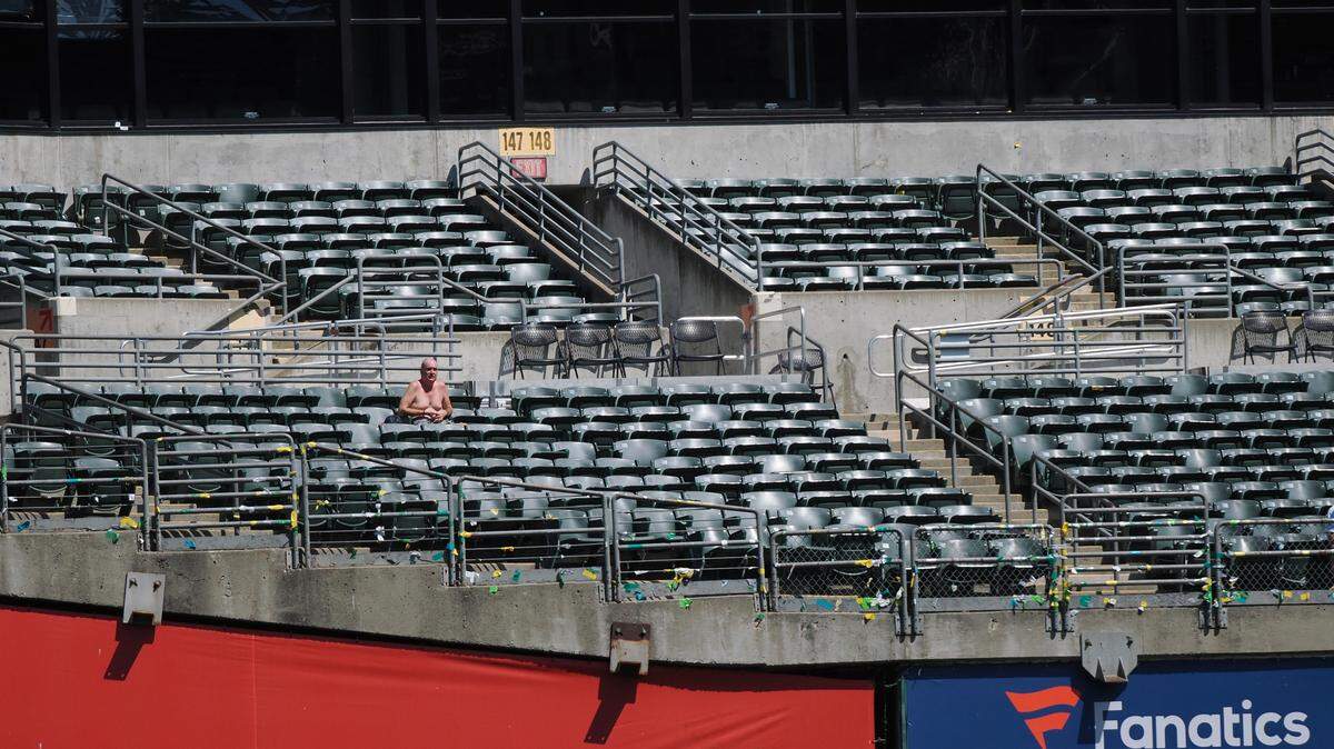 A shirtless fan sits in the stands during the eighth inning between the Oakland Athletics and Kansas City Royals at Oakland-Alameda County Coliseum.