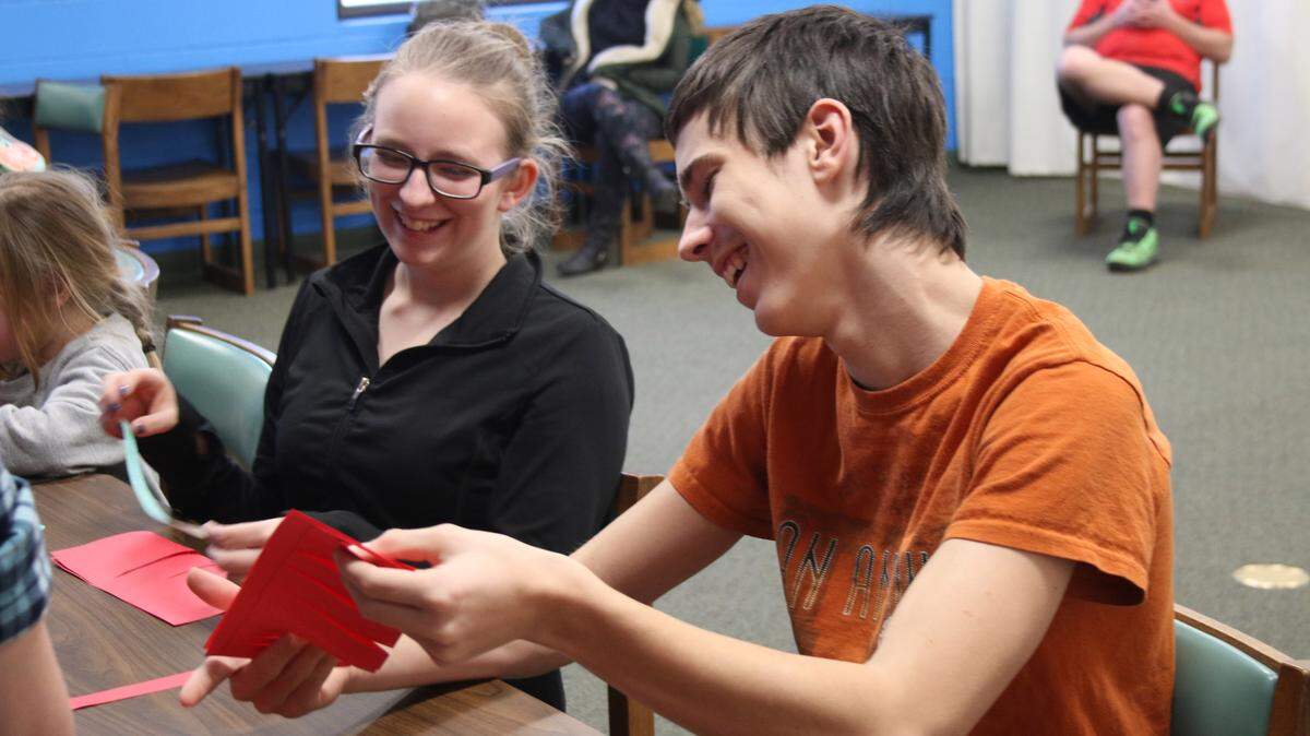 Andrea Logan, 13, and Damien Logan, 14, share a laugh while making paper lanterns at the Chinese New Year program at the Lee’s Summit Library.