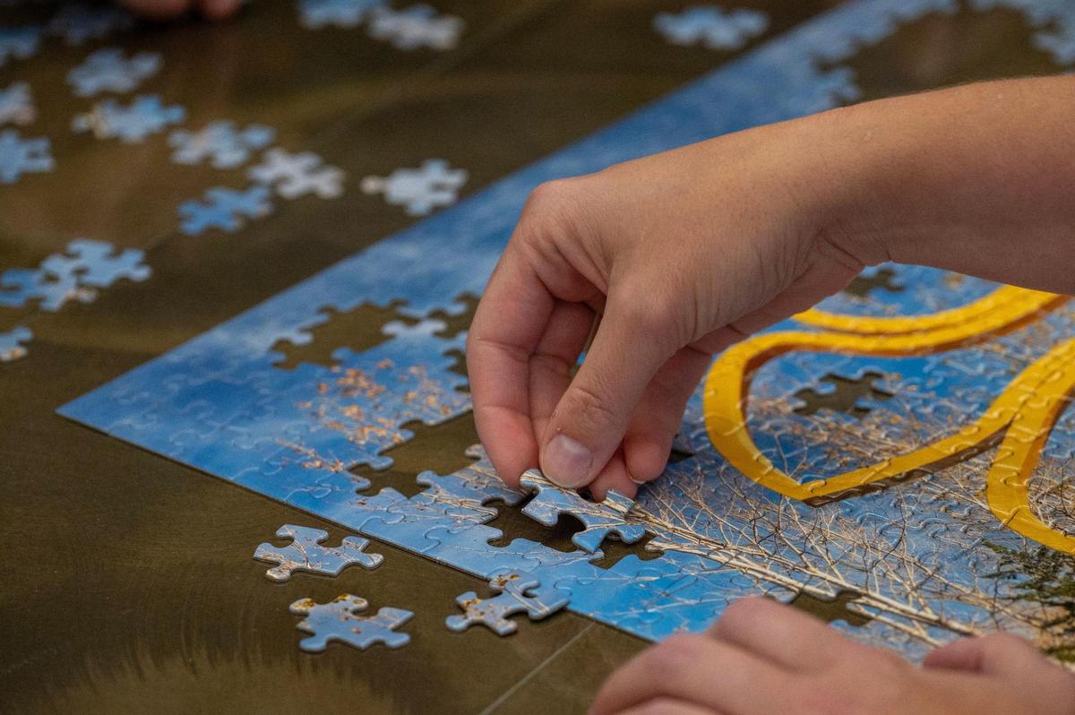 A team member from We Come in Pieces nears completion of the 500-piece puzzle during the Puzzle Palooza competition .