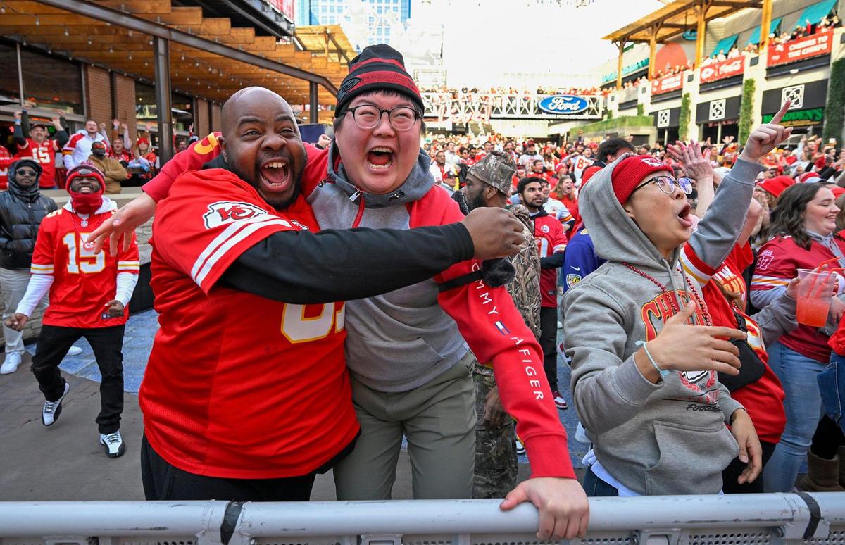 Jimmie Clark of East St.Louis, hugs Andrew Kang of KC, as the Chiefs score during the AFC Championship game against the Baltimore Ravens during a watch party on Sunday, Jan. 26, 2024, at KC Power & Light. They watched the game with brother, Joonyoung Yang, right, who flew in from Korea today for the Chiefs game.