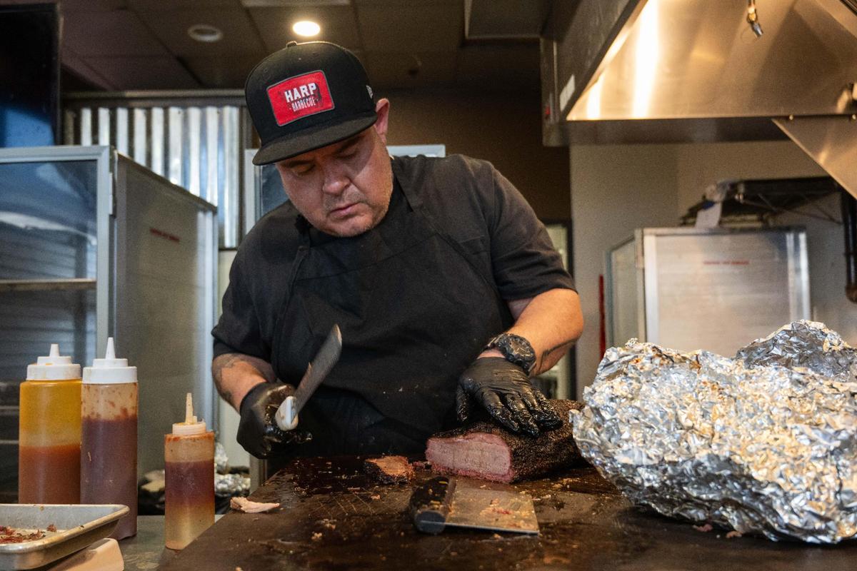 Tyler Harp, owner of Harp Barbecue, slices brisket for a tray at its new location in Overland Park on Wednesday, Nov. 13.