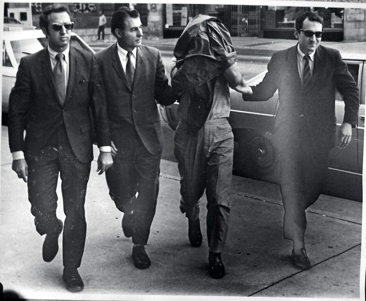 In 1970, William Ouseley, right, and fellow FBI agents arrested Kansas City crime boss Nick Civella, who hid his face from cameras.