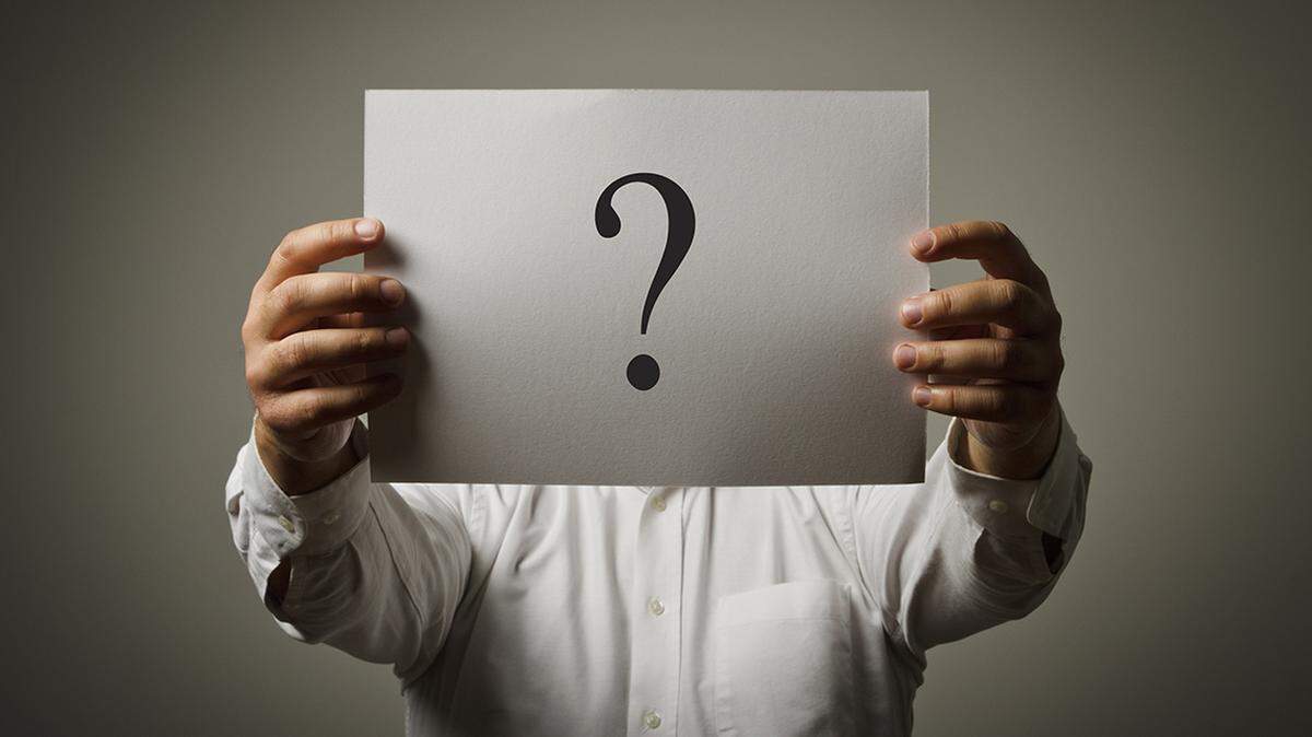 Man holding white paper with question-mark. Man having no answers to a question.