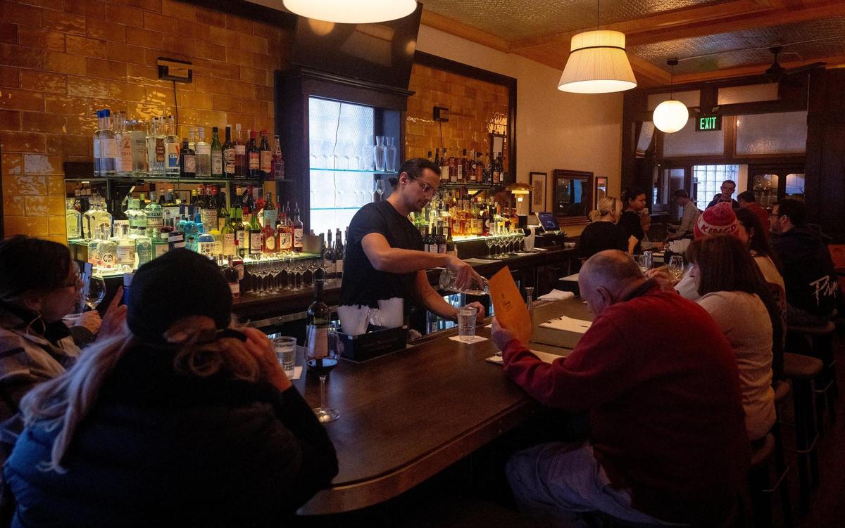 Bartender Michael Phillips fills a patron’s glass at Vita’s Place on Thursday night.