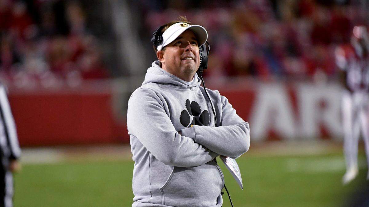 Missouri coach Eliah Drinkwitz looks at a replay during the second half of the team’s NCAA college football game against Arkansas on Friday, Nov. 26, 2021, in Fayetteville, Ark. (AP Photo/Michael Woods)