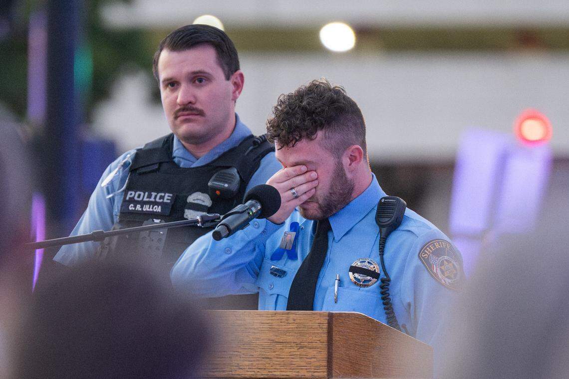 Deputy Blake Fisher of the Greenwood County, Kansas Sheriff's Department sheds tears as he reads a tribute to his friend, slain KCKPD officer Hunter Simoncic, at a candlelight vigil in his honor, on Thursday, Aug. 28, 2025, in Kansas City, Kansas.