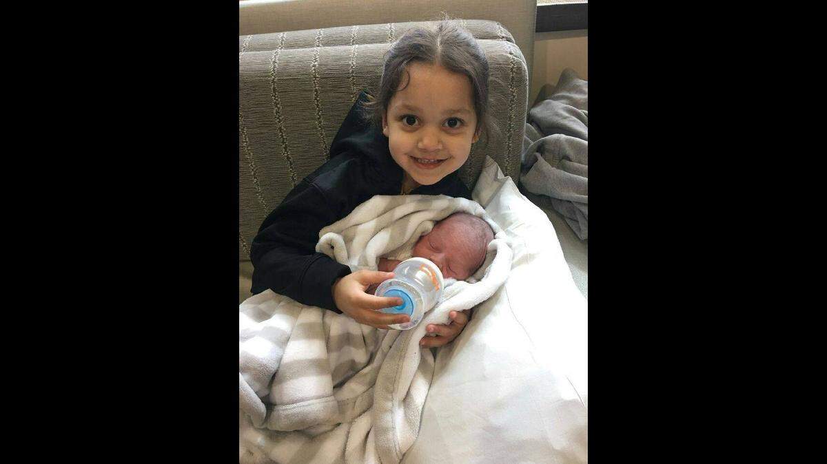 Amiyah Bradley is pictured with her half-brother shortly after he was born. Amiyah was killed when her mother allegedly drove into the Kansas River last week. The infant was critically injured.