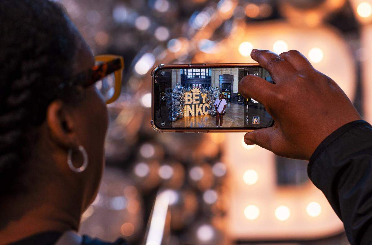 Lichon Rose Ramsey takes a photo of her daughter Michael Jones on Friday at Union Station. Visitors at Union Station were greeted by the bright Beyoncé sign as they entered the facility.