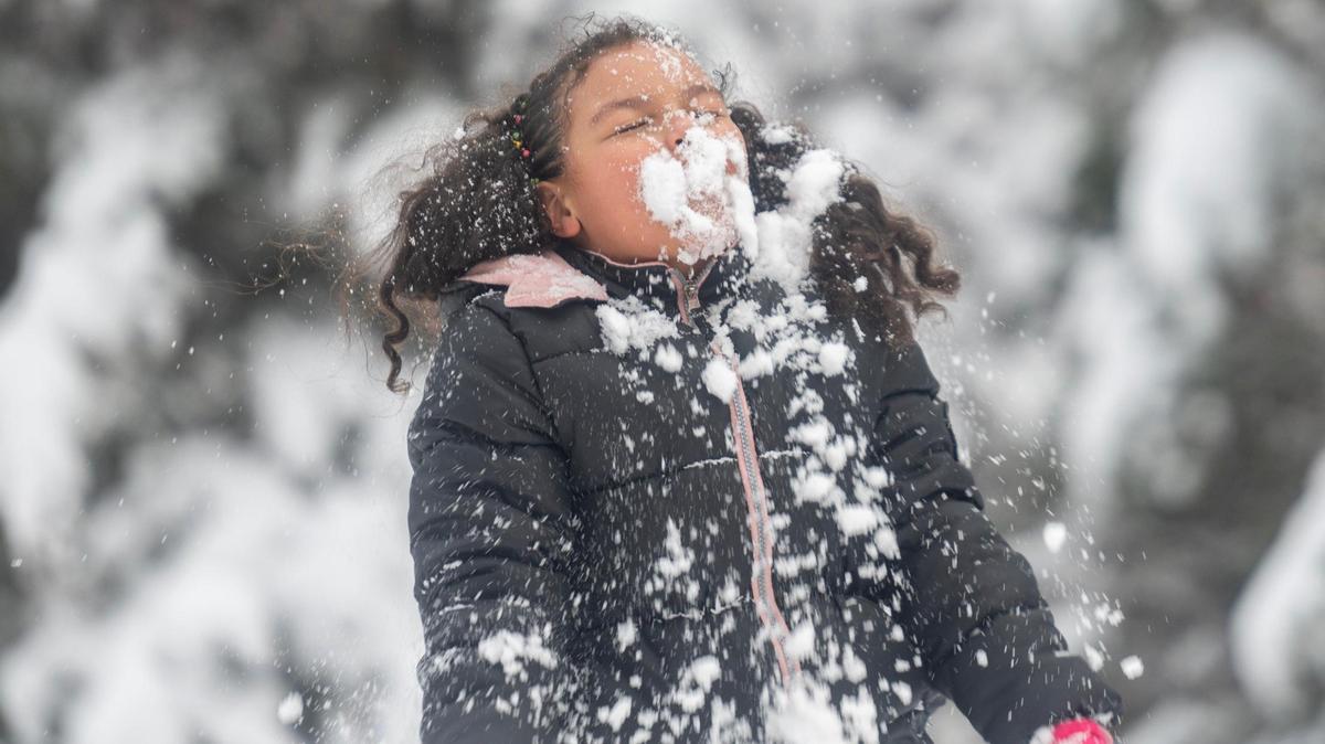 Six-year-old Kaliah Kowalski playfully throws snow in her face on Tuesday, Jan. 9, 2024, in Kansas City. A winter storm covered the Kansas City metro area with several inches of snow.