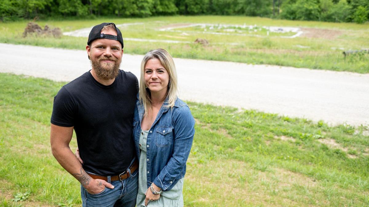 Nathan and Kristyn Frazee pose for a photo near a plot of land where they started building their new home near Warrensburg, Missouri. The couple say they paid Eric Eberhart thousands of dollars for shoddy work.
