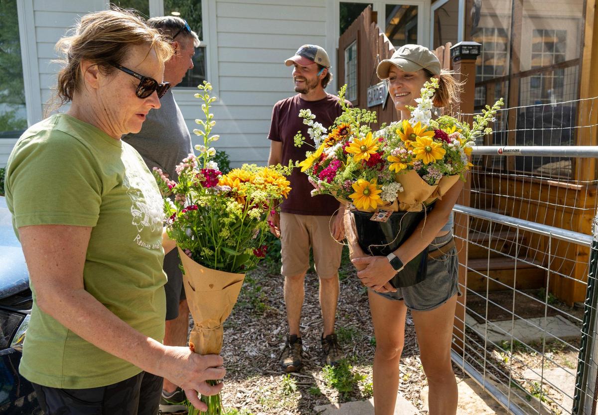 Ashley Hutchison, owner of Fern’s Farmette, looked on as Sue Dietze of Olathe examines her newly acquired flower subscription bouquet in Eudora, Kansas.