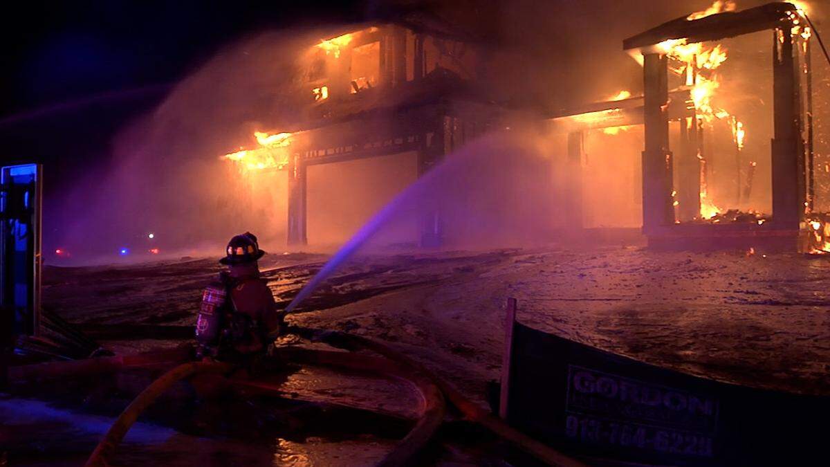 A pre-dawn two-alarm blaze engulfed three houses under construction and threaten a nearby occupied home in southern Overland Park, a spokesman for the fire department said. No injuries reported.