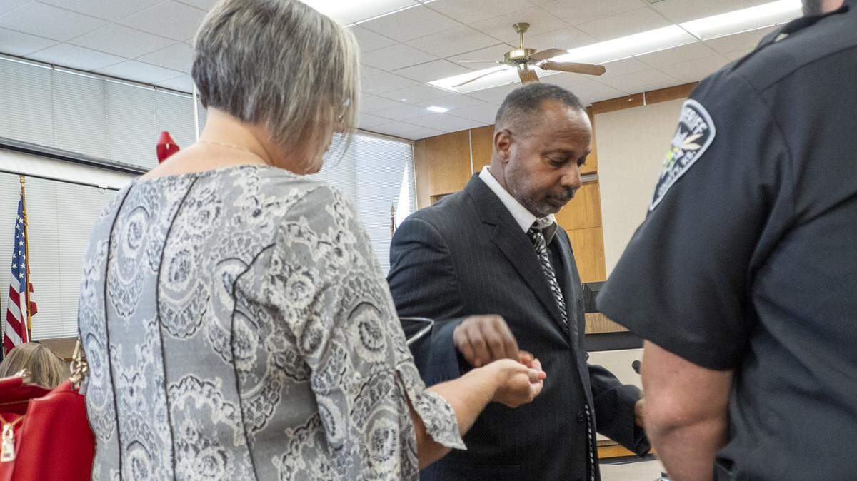 Linus Thuston hands his wedding ring to his wife before being handcuffed following a Sept. 4, 2024, hearing in Neosho County District Court. 