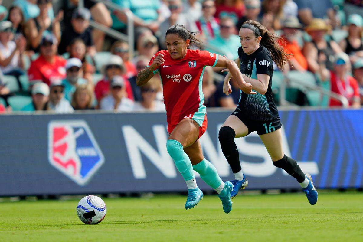 Kansas City Current midfielder Debinha, left, races past NJ/NY Gotham FC midfielder Rose Lavelle during Saturday’s NWSL match at CPKC Stadium.