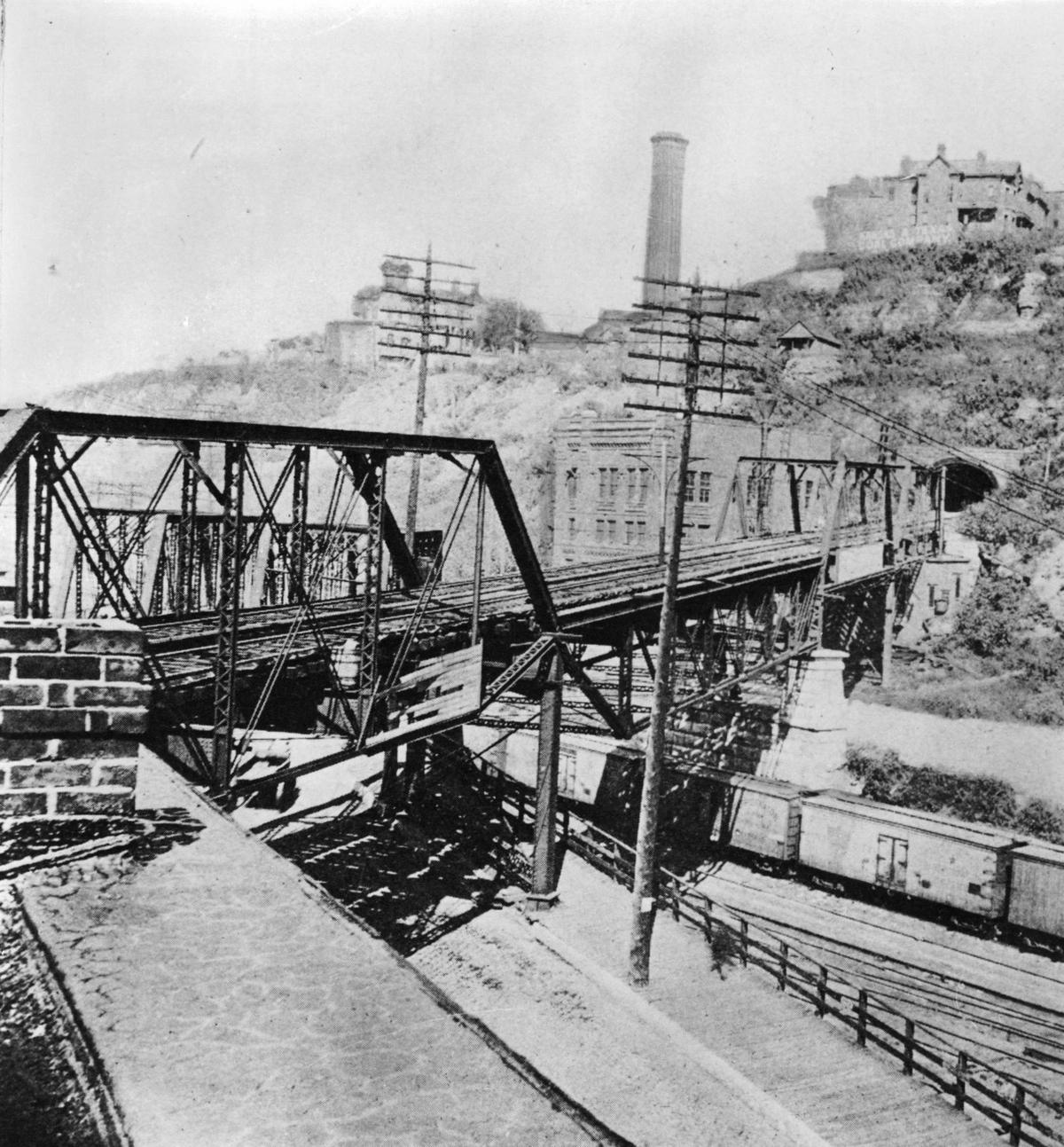 The west entrance of the tunnel and part of the 8th Street viaduct, or “L Road,” are shown in this photograph taken about 1895. The powerhouse for the cable railway is at the left of the tunnel entrance. The ÒL-RoadÓ continued on across the West Bottoms and the Kaw River to Kansas City, Kansas.
