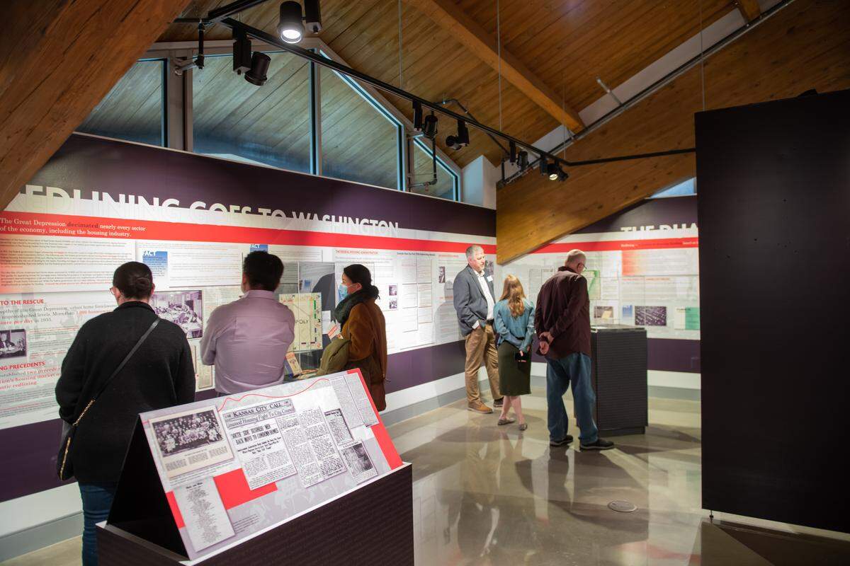 “People exploring the “Redlined: Cities, Suburbs and Segregation,” exhibit during its time at the Johnson County Museum in 2022. While it’s no longer in the museum, people can find its content online. 