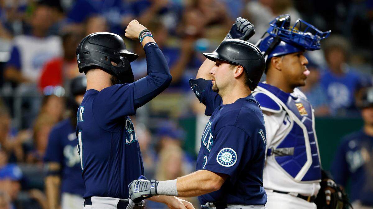 Royals catcher Salvador Perez (right) stood by as the Seattle Mariners’ Jesse Winker (left) congratulates Cal Raleigh at home plate after Raleigh’s two-run home run against the Kansas City Royals during the sixth inning at Kauffman Stadium in Kansas City on Saturday, Sept. 24, 2022.