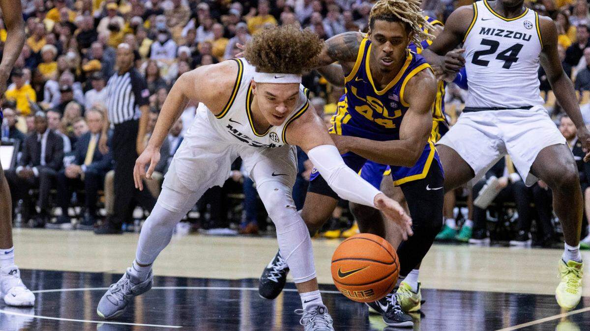 Missouri’s Noah Carter, left, grabs the ball in front of LSU’s Adam Miller, right, during the second half of a game Wednesday, Feb. 1, 2023, in Columbia, Mo. Missouri won 87-77.