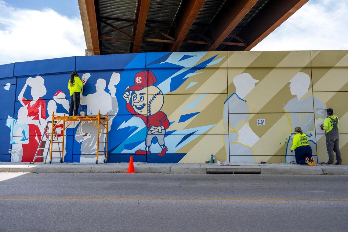 Phil Shafer, left, Mariah Markt and John Raux collaborate to paint a section of the mural designed by Sike Style Industries.